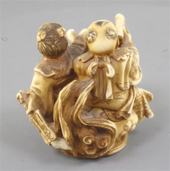 A Japanese ivory okimono of two boys with a Buddhist lion, Meiji period, height 5cm